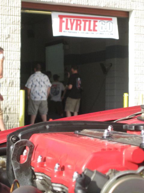 1994 Ford Probe - Close-up of a red engine component with a gathering of people visible in the background.
