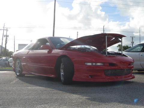 1994 Ford Probe - A red 1994 Ford Probe is parked with its hood open, showing the engine bay.