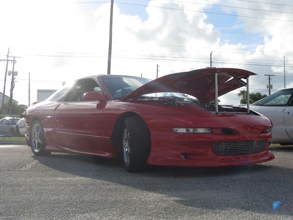 Red 1994 Ford Probe with hood open, front 3/4 view