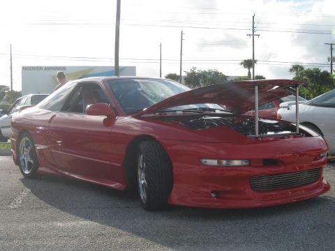 1994 Ford Probe - A red 1994 Ford Probe is parked with its hood open, showing the engine bay.