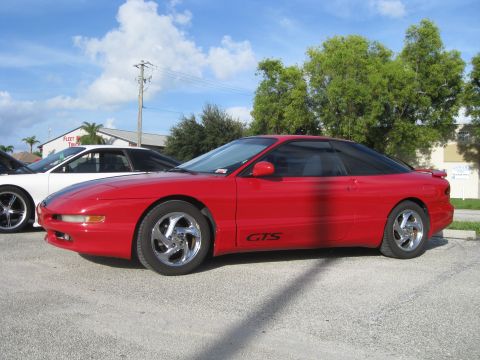 1994 Ford Probe - Side view of a red 1994 Ford Probe GTS with chrome wheels.