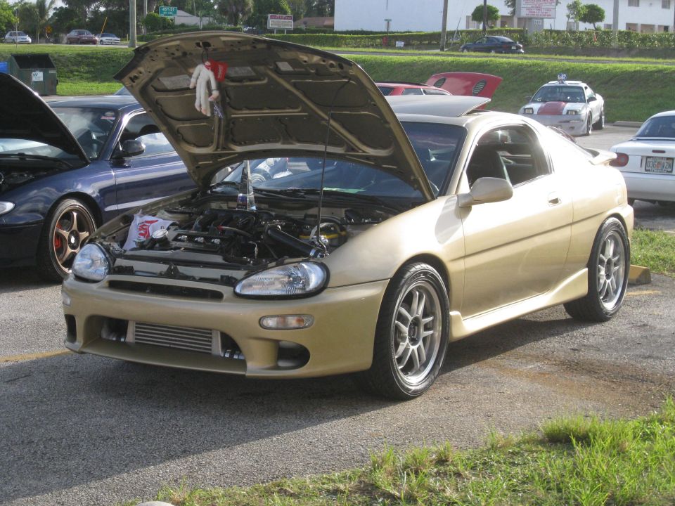Gold coupe with hood open, aftermarket intercooler visible