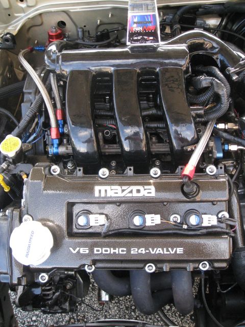 1994 Ford Probe - The engine bay features a prominent Mazda V6 engine with performance modifications.