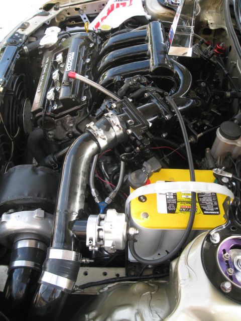 1994 Ford Probe - Close-up view of a modified engine bay a turbocharger and custom intake piping.