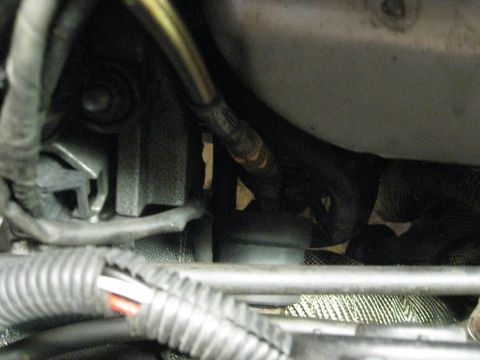 1994 Ford Probe - Close-up view of engine components including the exhaust manifold and wiring harness.