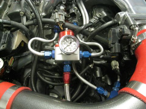 1994 Ford Probe - Close-up view of an aftermarket fuel pressure regulator installed in an engine bay.