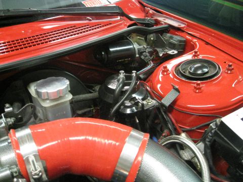 1994 Ford Probe - Close-up view of a modified engine bay, a red silicone intake hose and a silver brake fluid reservoir.