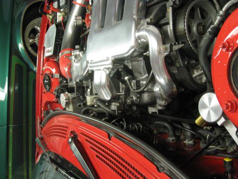 1994 Ford Probe - Close-up view of a modified engine bay, showing polished metal components and vibrant red and green paint.