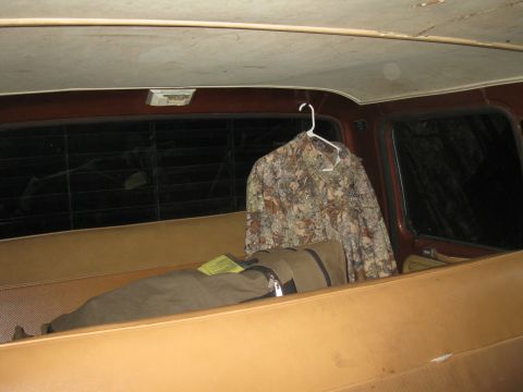 1977 Ford F-250 - Interior of a vehicle with a camouflage jacket and a bag on the seat.