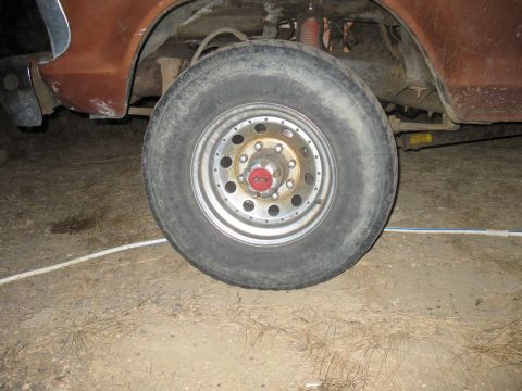 1977 Ford F-250 - Close-up of a truck's wheel and suspension components, showing the tire and rim detail.