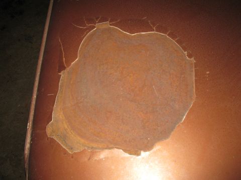1977 Ford F-250 - A large rust patch mars the brown paintwork of a vehicle panel, with the Supermotors.net logo in the corner.