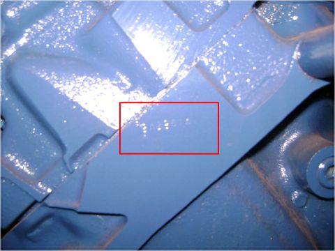 1972 Ford Ranchero - Extreme close-up of a Ford-blue engine block casting with a faint stamped alphanumeric code highlighted by a hand-drawn red rectangle. The…