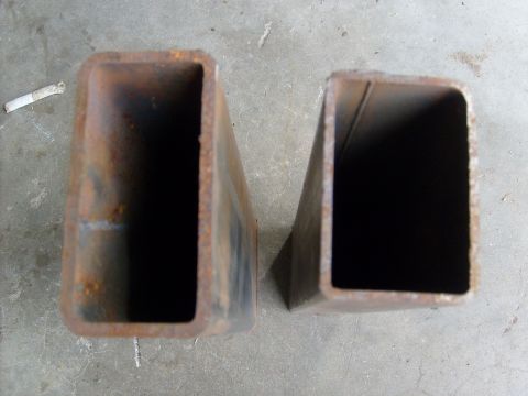 1986 Ford Bronco - Two rusty steel tubes are shown on a concrete floor.