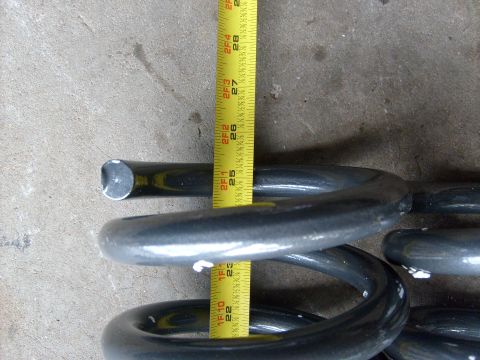1986 Ford Bronco - Measuring a suspension coil spring with a tape measure. The spring appears to be a replacement part.