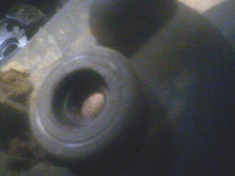 1994 Ford Escort - A close-up view of a mechanical part, possibly from an engine or drivetrain, with a gear visible in the background.