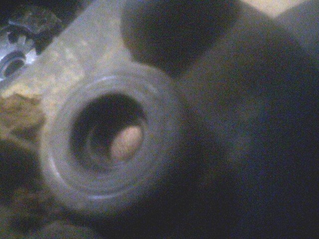 Close-up of a metal part with a hole and a gear visible