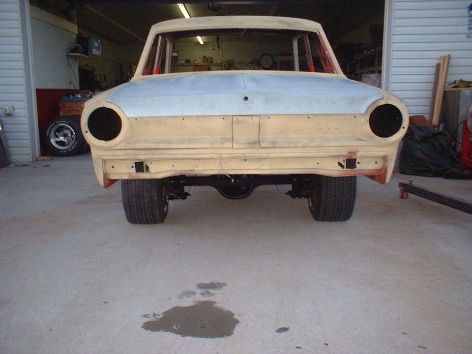1964 Ford Falcon project car in garage, front view, primer hood, no grille