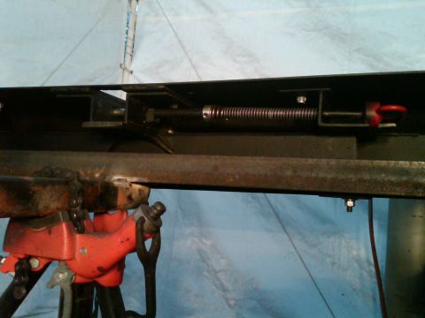 1987 Suzuki Samurai - A close-up view of a vehicle's bumper assembly, showing mechanical components like a spring and hook.