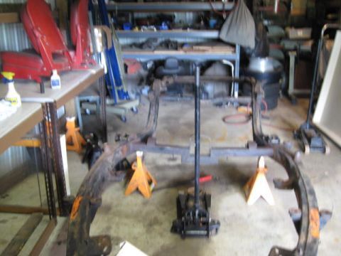 1963 Ford Galaxie - Car frame assembly on jack stands, likely undergoing restoration or repair.