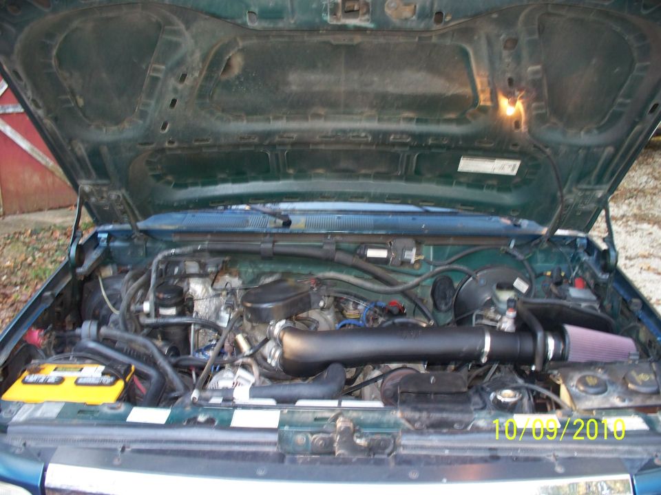 Green Ford truck engine bay with black intake tube and red cone air filter