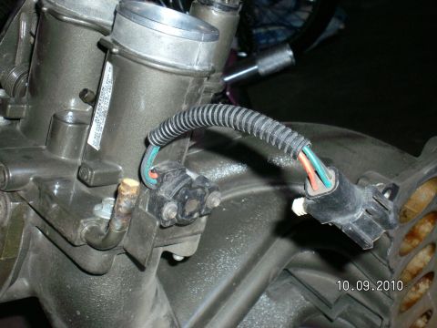1996 Ford Bronco - Close-up of two electrical sensor connectors and a corrugated wiring harness on an engine casting, dated 10.09.2010.