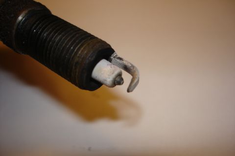 2003 Chrysler Town & Country - This is a close-up view of a used spark plug, showing its condition.