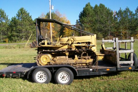 2000 Chevrolet Tahoe - Crawler tractor being transported on a flatbed trailer.