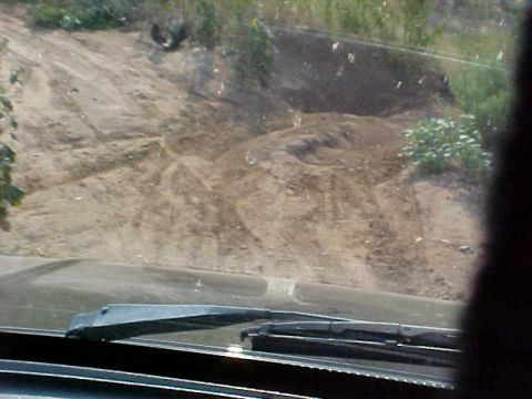 1989 Ford Bronco - Looking out from the windshield at a dusty, off-road landscape. Windshield wipers are in view.