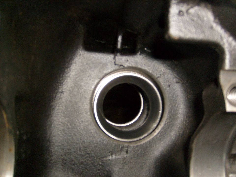Close-up of a cracked engine component with a circular opening
