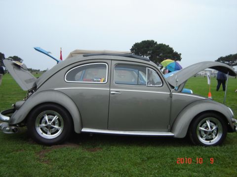 1993 Ford Bronco - A gray Volkswagen Beetle is displayed with its front and rear hoods open at an outdoor event.