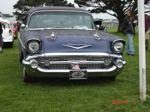 1993 Ford Bronco - A classic 1957 Chevrolet Bel Air is displayed on a grassy field, a distinctive grille and custom flame paintwork.