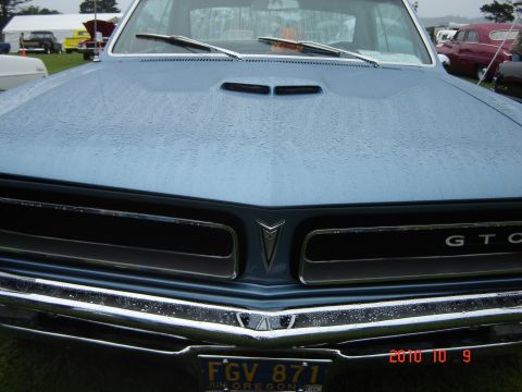 1993 Ford Bronco - Front view of a blue 1967 Pontiac GTO with water droplets on the hood and grille.