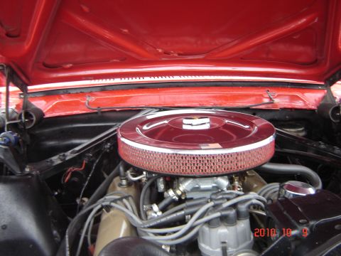 1993 Ford Bronco - The engine compartment of a classic car is shown, a V8 engine and a prominent red air filter housing.