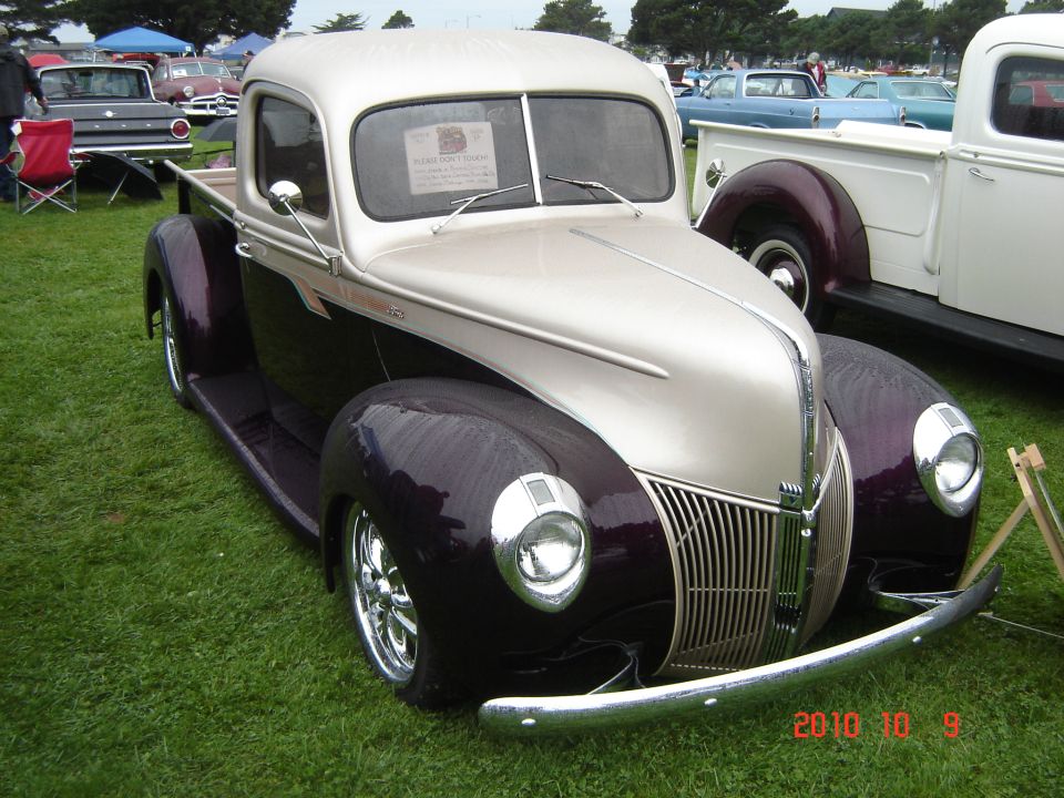 Two-tone pickup truck with chrome grille and wheels, parked on grass
