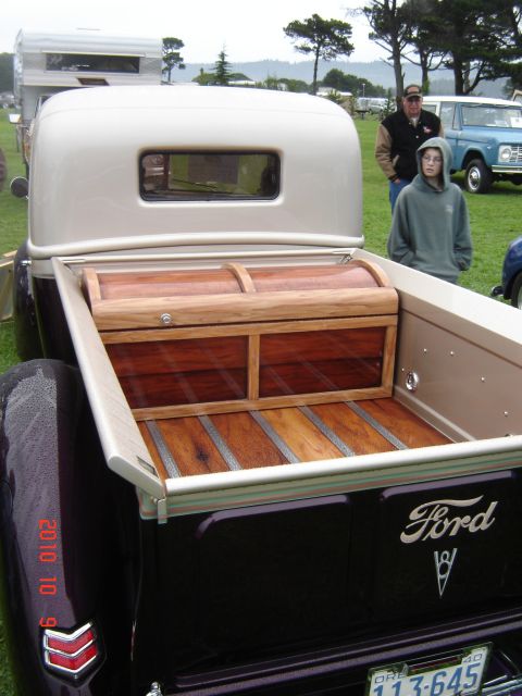 1993 Ford Bronco - Ford pickup truck bed features custom wood work and a wooden chest. Another vehicle is parked behind it.