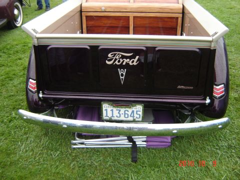 1993 Ford Bronco - A Ford pickup truck with a wooden bed insert and chrome bumper is parked on grass.