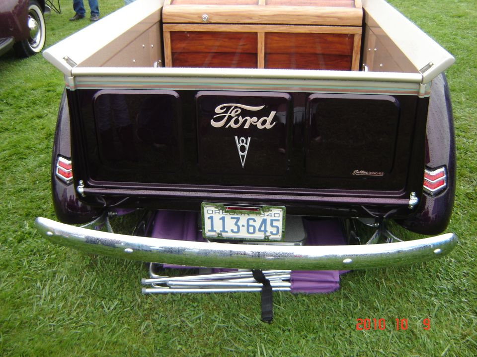 Dark purple Ford pickup truck rear view with wooden bed insert and chrome bumper