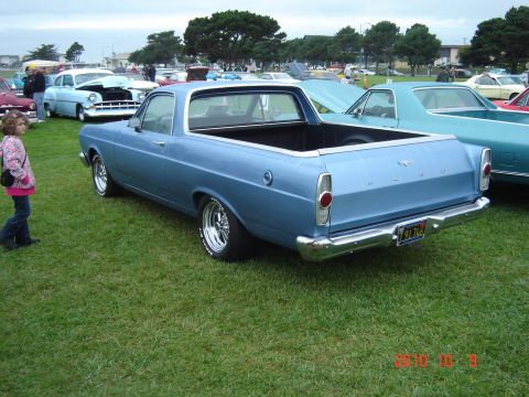 1993 Ford Bronco - A blue 1967 Ford Ranchero is parked on grass at an outdoor car show, with a young girl walking past.