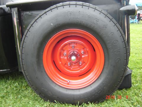1993 Ford Bronco - Close-up of a spare tire with a red rim, mounted on a vehicle's exterior.