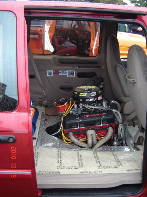 1993 Ford Bronco - A Chevrolet V8 engine is installed in the rear of a red vehicle, with another vehicle visible through the window.