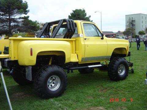 1993 Ford Bronco - Lifted 1973 Chevrolet pickup truck with a custom roll cage and off-road tires on display.