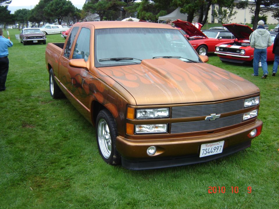 Copper pickup truck with flame graphics, custom hood, and chrome wheels