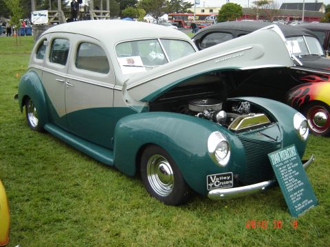 1993 Ford Bronco - Two-tone 1940 Ford Deluxe sedan on display at a car show, hood up revealing the engine.