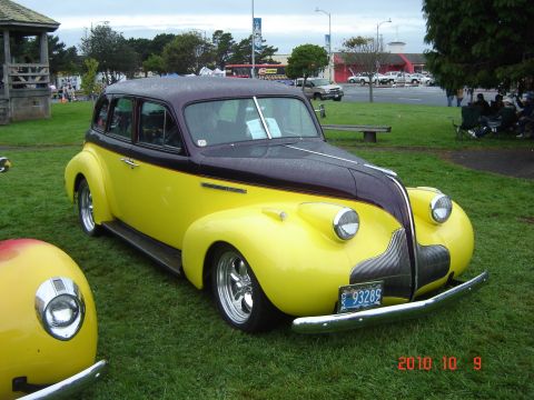 1993 Ford Bronco - A vintage two-tone yellow and purple sedan is displayed at an outdoor event.