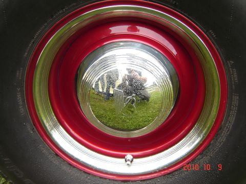 1993 Ford Bronco - Close-up of a vintage wheel with a red rim and chrome hubcap.