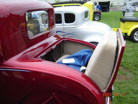 1993 Ford Bronco - Several classic cars are parked on a grassy field, with the trunk of a red car open.