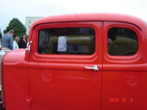 1993 Ford Bronco - Red vintage car with chrome door handle and two windows visible.