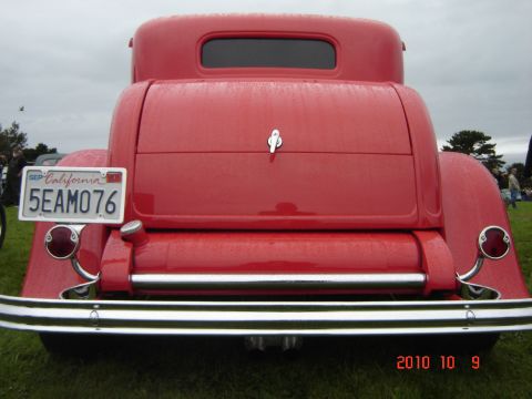 1993 Ford Bronco - The rear of a classic red hot rod coupe is shown with a California license plate and chrome bumper.