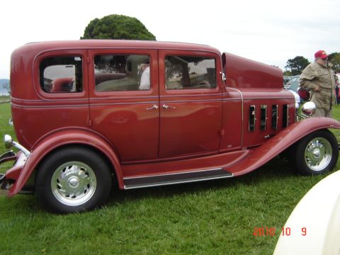 1993 Ford Bronco - A classic red sedan with a distinctive grille and hood design is displayed outdoors.