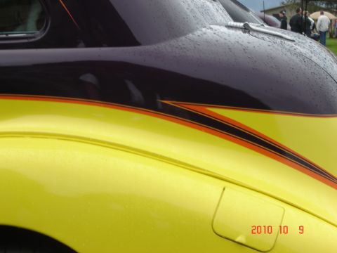 1993 Ford Bronco - A custom hot rod with a two-tone paint job and pinstriping is shown with water droplets on its surface.